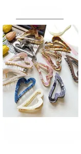 Macro detail of various colorful acetate heart hair claws on a desk with flowers