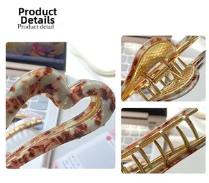 Detail view of heart-shaped acetate hair claw clip with sturdy golden metal spring