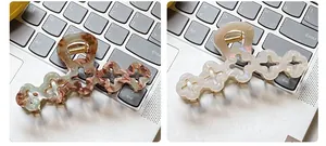 Detail showing elegant tortoiseshell and pearly white large floral hair claw clips