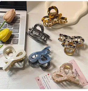 Detailed view of six patterned acetate bow-shaped hair claws in tortoiseshell and marble