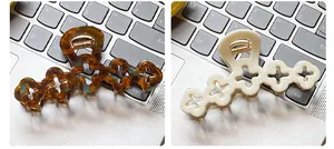 Detail view of flower hair claws in tortoiseshell and cream white on keyboard