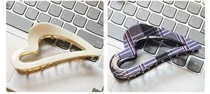 Detail of heart acetate claw clips in cream and plaid patterns with metal base