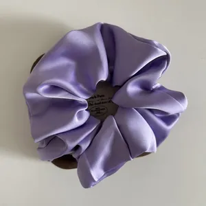 Detailed view of lilac satin scrunchie with French style elegant glossy silk texture
