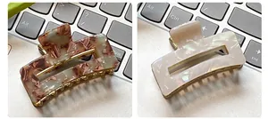 Close-up of marble pattern and pearl square hair clips with golden metal base