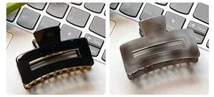 Detail view of square hollow hair claws in glossy black and frosted smoky grey colors
