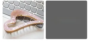 Detailed view of pink marble acetate heart hair claw clip with golden metal frame
