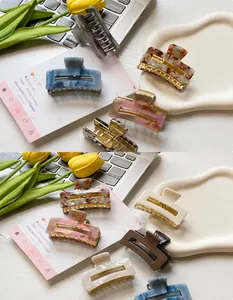 Close-up of assorted square hair claws in marble and tortoiseshell patterns on a desk