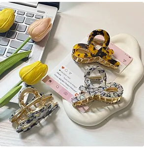 Macro view of leopard print acetate hair claw clips on decorative ceramic tray