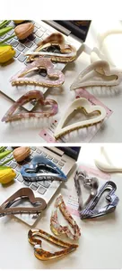 Detail of hollow heart hair claw clips in various acetate marble patterns and textures