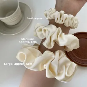 Three sizes of elegant cream satin scrunchies shown in 2cm 4cm and 6cm widths
