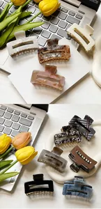Various small square hair claws in marble, checkered and solid patterns on a desk