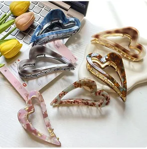 Detail showing six assorted acetate heart hair claws in marble and leopard patterns