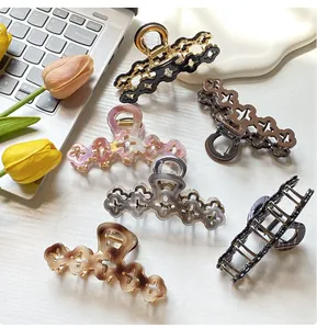 Flat lay of six floral hollow hair claws in various marble textures on a clean workspace