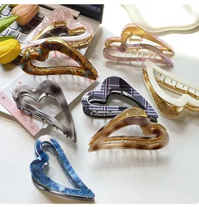 Detail of assorted heart-shaped acetate claw clips with golden metal teeth for hair