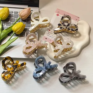 Elegant acetate bow hair claws in diverse marble patterns and leopard prints