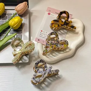 Elegant acetate bow hair claws in tortoiseshell and marble patterns for women