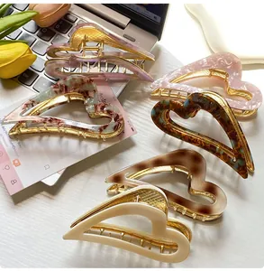 Close-up of heart-shaped acetate hair claws in five marble and leopard patterns