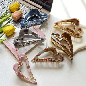 Elegant heart-shaped acetate hair claws in various marble patterns for stylish hairstyling