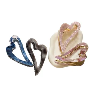 Set of minimalist heart-shaped acetate hair claws in marble patterns and pastel colors