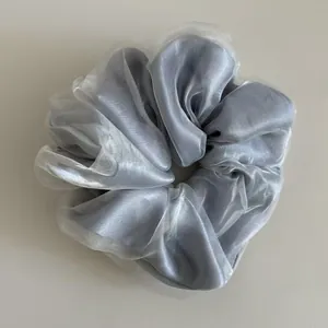 Detail of silver-grey tulle scrunchie featuring layered organza and satin textures