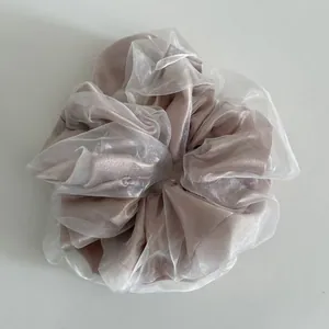 Detail of double-layered mesh scrunchie with pink satin core and white organza texture