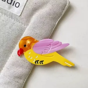 Pince à cheveux oiseau coloré en acétate avec ailes violettes et fini perlé