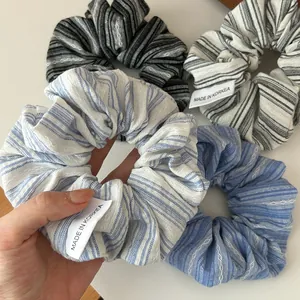 Gros plan de quatre chouchous en tissu rayé bleu sel de mer et motifs variés