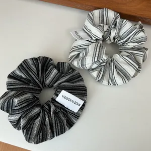 Texture détaillée de chouchous en tissu rayé noir et blanc avec étiquettes tissées coréennes