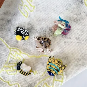 Marine ocean animal acetate hair claws featuring turtles and fish on cream fabric
