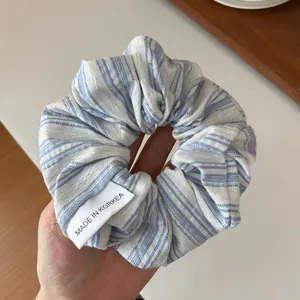 Détail d'un chouchou en tissu à rayures bleues et blanches avec couture ondulée