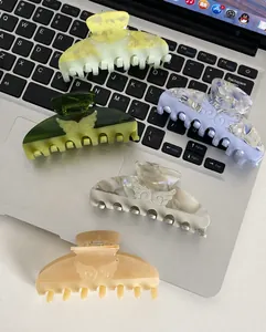 Detailed set of four acetate hair claws in pastel marble colors on a laptop keyboard