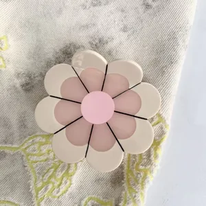 Sunflower shaped acetate hair claw clip in cream and pink colors with glossy finish