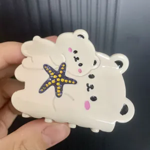 Creamy white bear hair claw clip with purple starfish accent for elegant hair styling
