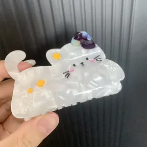 Cute white marble acetate hair claw clip in a cat shape with yellow star patterns