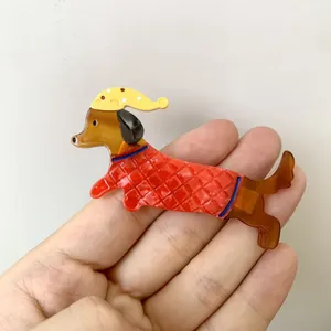 Broche teckel en acétate avec bonnet de nuit jaune et tenue à motif matelassé rouge