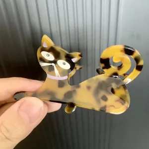 Tortoiseshell acetate cat hair clip with purple collar and rhinestone detailing for women