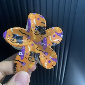 Détail de la pince à cheveux orange d'Halloween avec motifs de chats noirs et étoiles