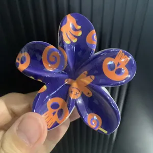 Détail d'une pince à cheveux violette avec tête de mort Halloween et motif UV