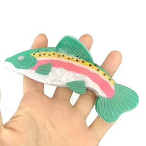 Fish-shaped large acetate hair claw clip with colorful striped patterns in green and pink