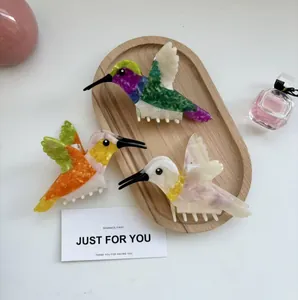 Pinces à cheveux colibri créatives en acétate marbré vibrant sur plateau en bois