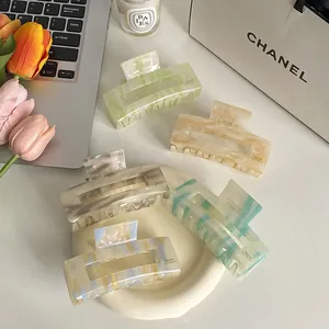 Pinzas para el cabello de acetato con textura de mármol en una bandeja de cerámica