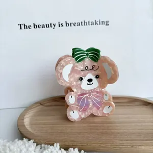Detail der Haarklammer aus rosa Acetat in Bärenform mit Schleife und Lila Akzenten