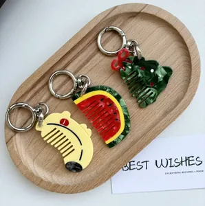 Detail of creative acetate hair combs in banana, watermelon, and tree shapes with keyrings