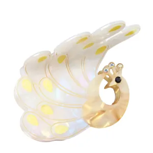 Detail of peacock hair claw clip with pearlescent acetate texture and rhinestone accents
