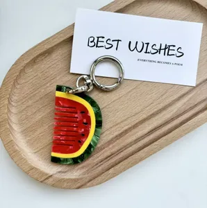 Close-up of watermelon-shaped acetate comb keychain with silver metal lobster clasp detail