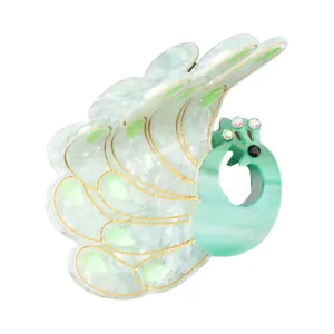 Macro shot of peacock acetate hair claw with mint green texture and sparkling rhinestones