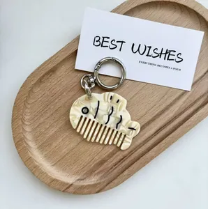 Close-up of cute cartoon dog acetate comb keychain with polished silver metal ring