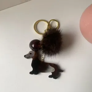 Porte-clés teckel mignon en résine marbrée avec pompon marron et mousqueton doré élégant
