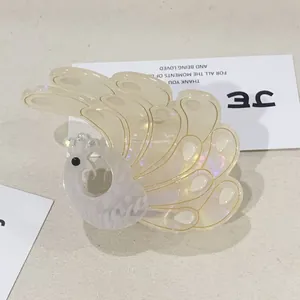 Elegant peacock hair claw clip in pearlescent acetate with gold detailing and crystal accents