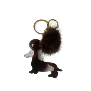 Pince à cheveux teckel en acétate avec pompon en peluche et anneau en métal doré